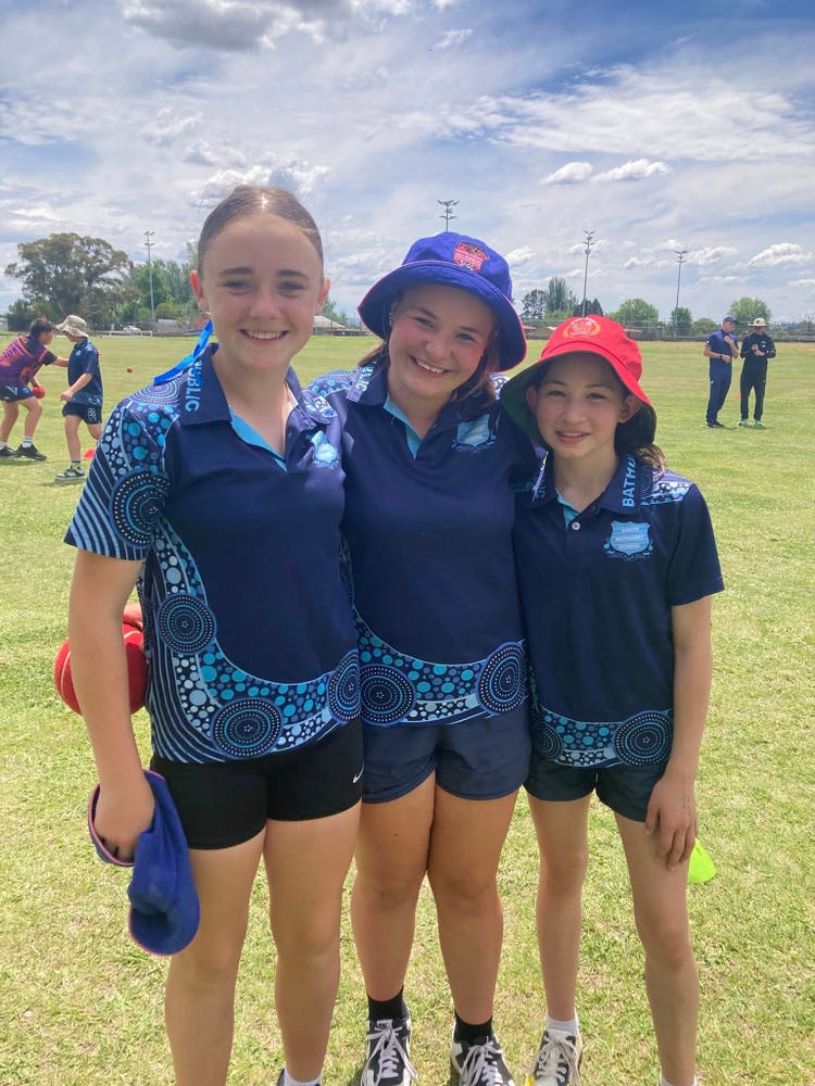 3 girls smiling on sport field