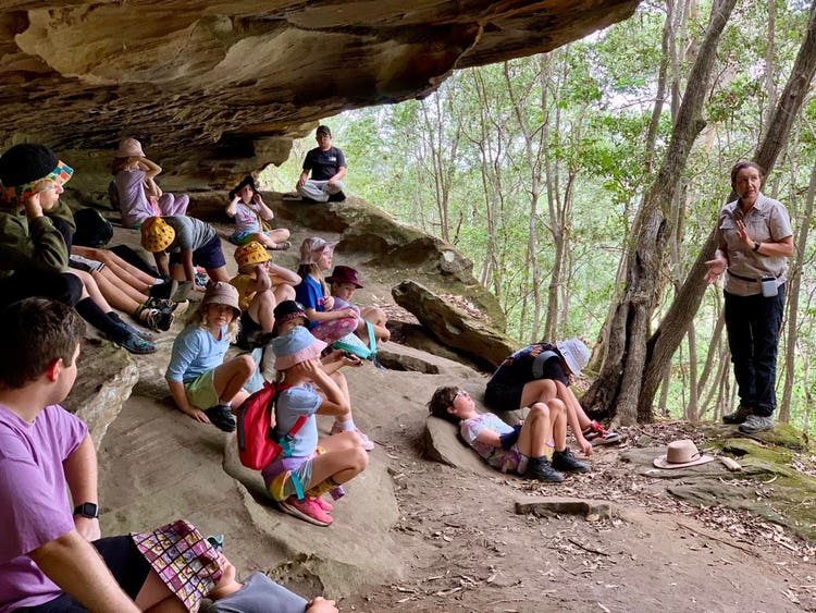 Class group sitting in a cave at school camp