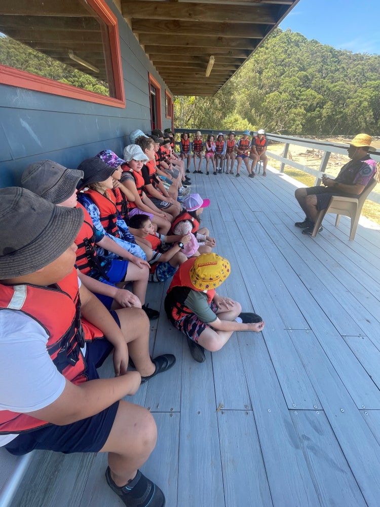 Students in life jackets listening to instruction