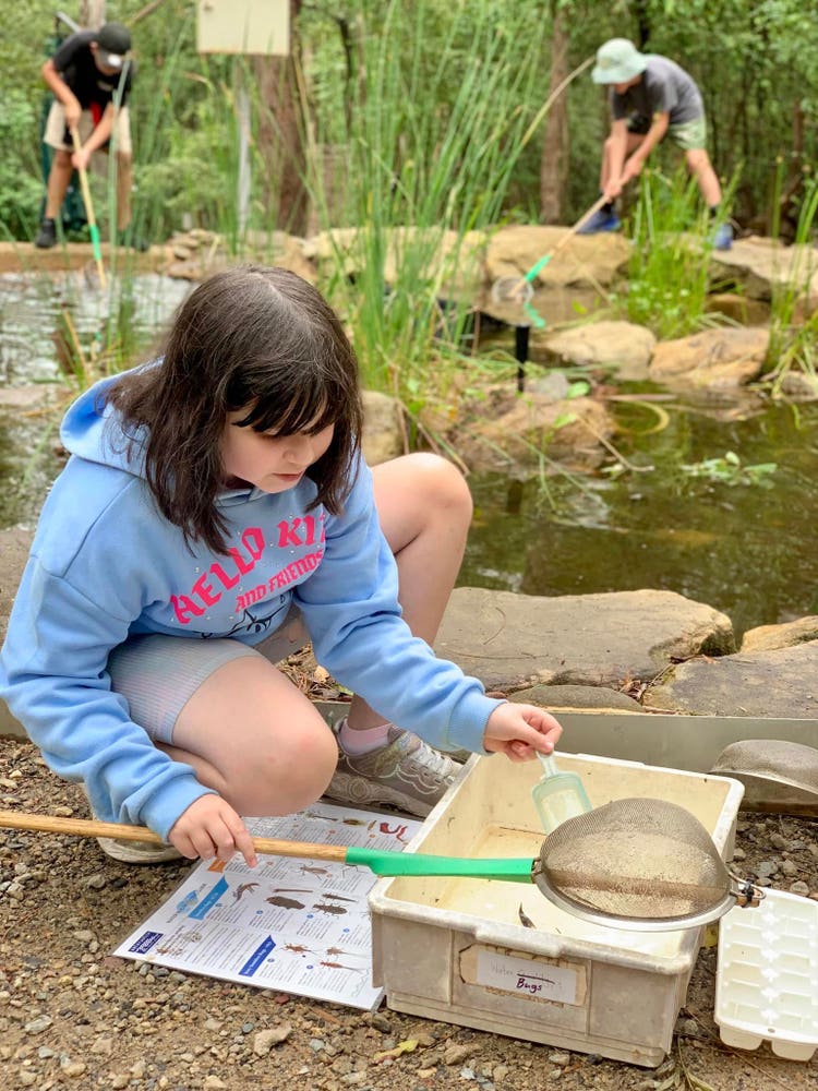 Female student by pond with fishing net